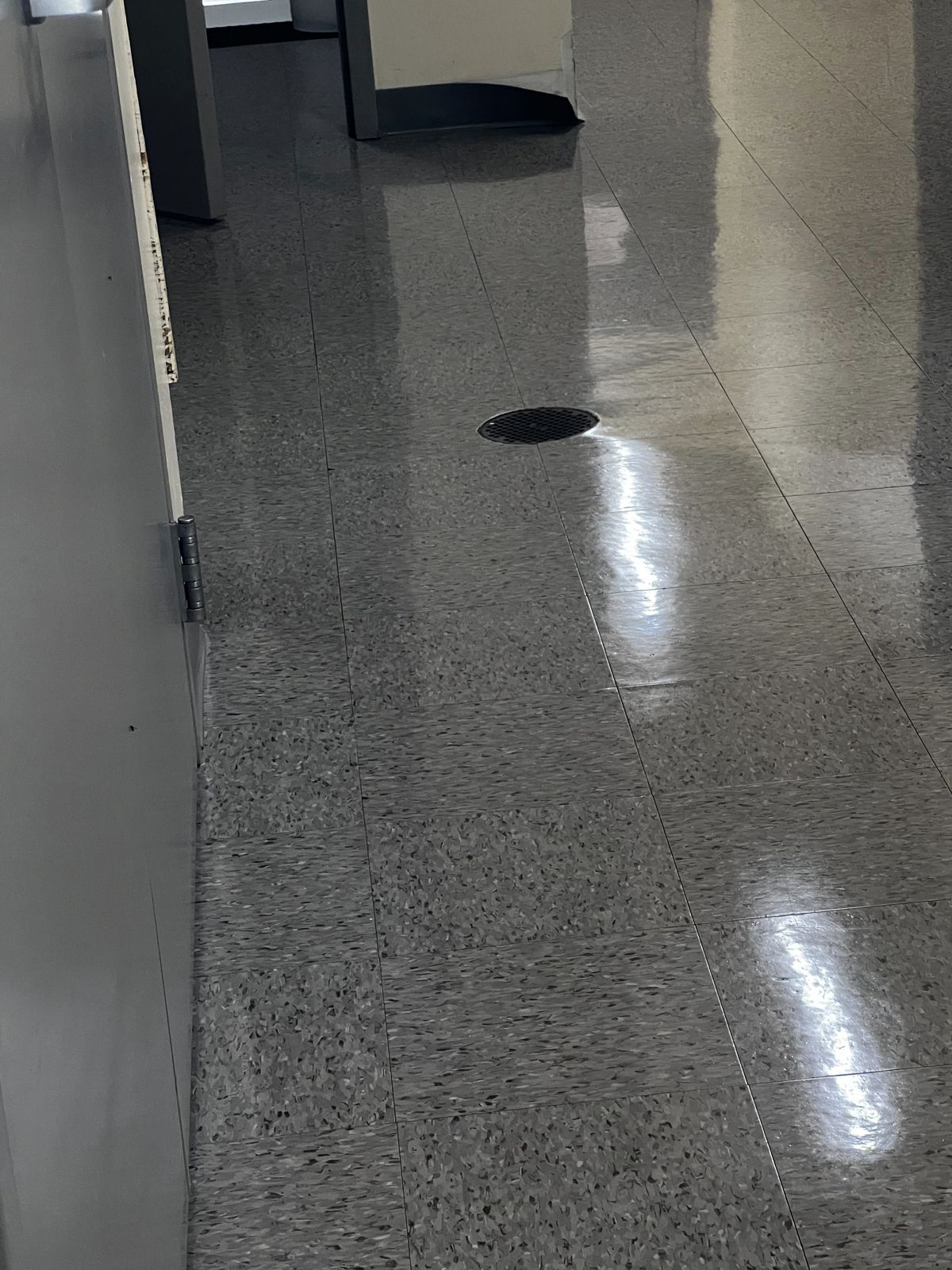 Dark gray VCT corridor with a high-gloss finish