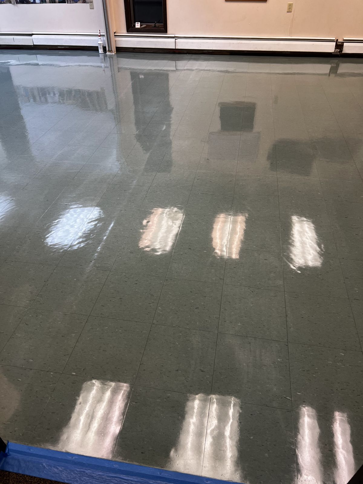Gray-green VCT room with a high-gloss finish and blue tape at the edge
