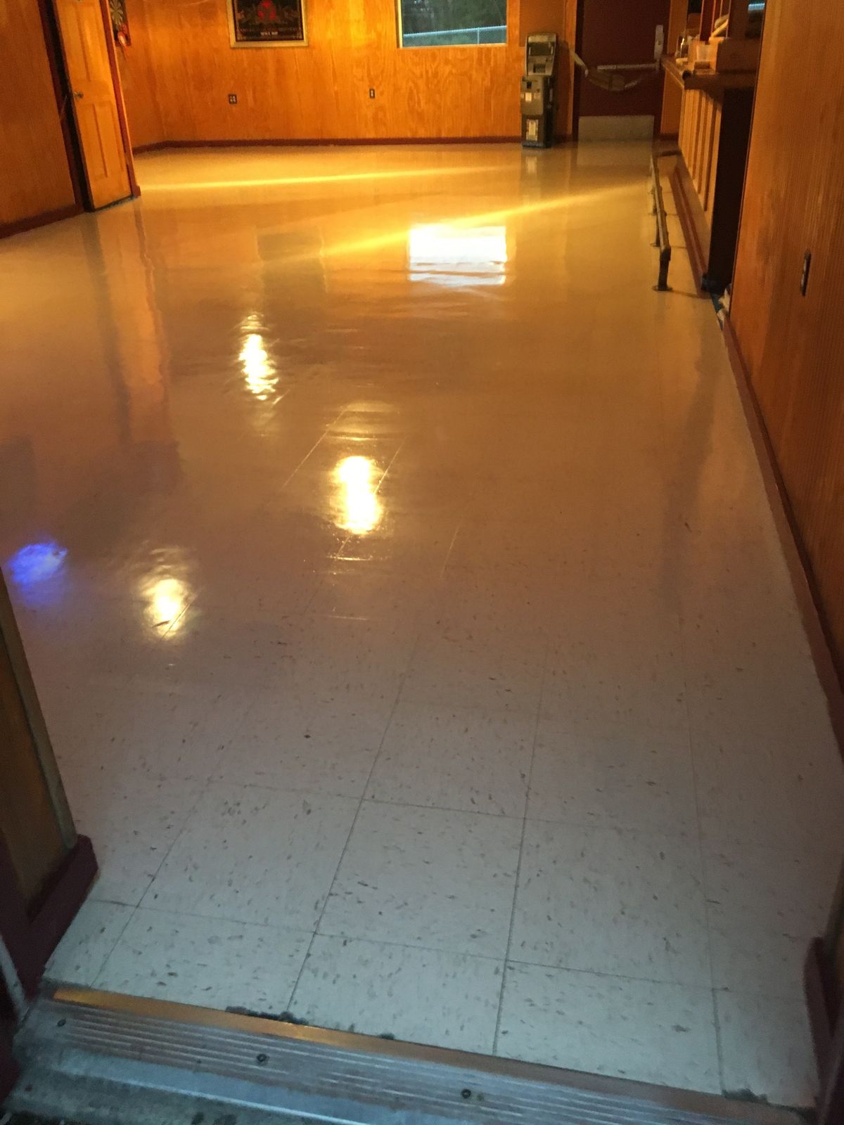 Beige VCT in a wood-paneled room with a high-gloss finish